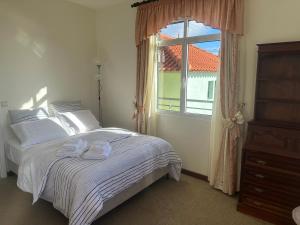 a bedroom with a bed and a window at The View House in Ponta do Sol