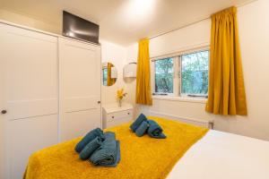 a bedroom with a bed with towels on it at Bos Chalet Natura - Rust en Natuur op de Veluwe Putten in Putten