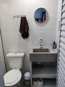 a bathroom with a white toilet and a sink at Loft 03 c ar condicionado proximo praias e Expocenter BC in Balneário Camboriú