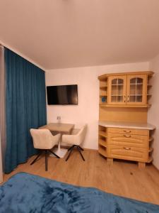 a room with a desk and a table and chairs at Appartement AquaQuelle in Bad Füssing