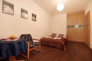 ザコパネにあるApartSerwis - Apartment U Sabały Centrumのベッド、テーブル、椅子が備わる客室です。