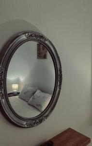 a mirror on a wall with a bed in a room at Family House Dim in Ioannina