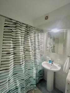 a bathroom with a sink and a shower curtain at Family House Dim in Ioannina