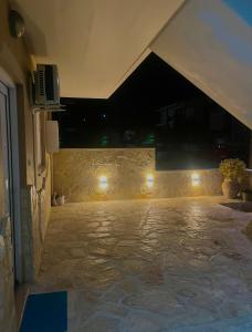 a room with a stone floor and a wall with lights at Family House Dim in Ioannina