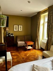 a living room with a couch and a table at Hôtel le Manoir du Soldat in Phalsbourg +15 photos