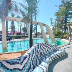 una gran piscina con un banco frente a ella en Apartamento Acequion, en Torrevieja