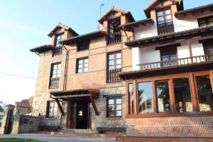 a large brick building with many windows at Posada La Cabaña De Salmon in Santillana del Mar