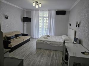 a living room with a bed and a couch at ORBI 4 Seasons ApartHotel in Batumi