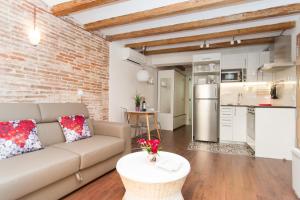a living room with a couch and a brick wall at Apartments Barcelona Sagrada in Barcelona