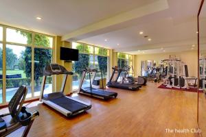 a gym with several treadmills and elliptical machines at Hotel Clarks Shiraz in Agra