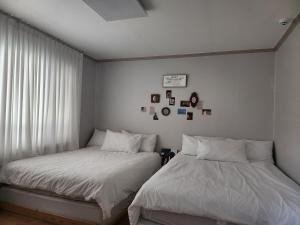 two beds sitting next to each other in a bedroom at Gwang An Stay in Busan