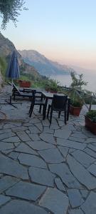 a picnic table and an umbrella on a stone patio at Le Finestre di Amalfi in Amalfi +10 photos
