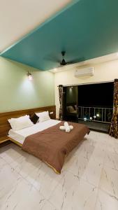 a large bedroom with a large bed with a brown blanket at Kashid Sunrise Resort in Kashid +30 photos
