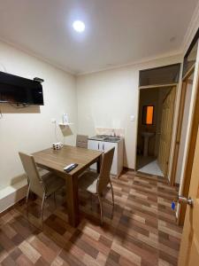 a dining room with a table and chairs and a kitchen at Apartamentos Lourdes in Antofagasta