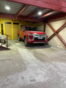 a red pickup truck parked in a garage at Apartamentos Lourdes in Antofagasta