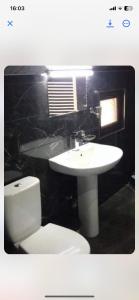 a bathroom with a white toilet and a sink at Sun in Kutaisi