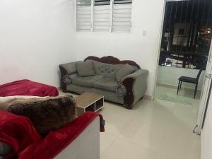 a living room with a couch and a table at Habitación económica in Santiago de los Caballeros