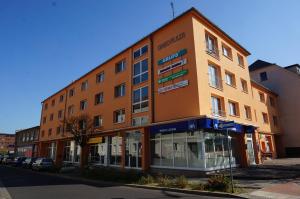 un gran edificio naranja al lado de una calle en Oneo-Plaza-Apartments, en Weißwasser