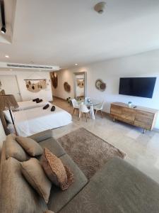 a large bedroom with a bed and a couch at Oceana by ABNA in Playa del Carmen