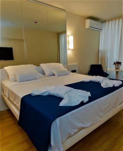 a bedroom with a large bed with blue and white sheets at Orbi City - "A" in Batumi +13 photos
