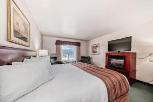 Postel nebo postele na pokoji v ubytování Grande Cache Inn & Suites