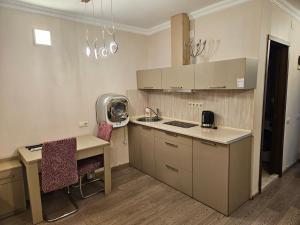 a kitchen with a sink and a desk with chairs at Premium Class In Batumi in Batumi