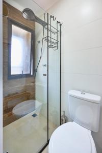 Un baño con ducha de cristal y un inodoro. en Studio Matira, próximo a praia, novo e moderno, en Ubatuba 15 fotos más