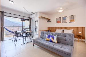 una sala de estar con un sofá y una mesa en Studio Matira, próximo a praia, novo e moderno, en Ubatuba