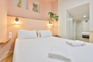 ein Schlafzimmer mit einem großen weißen Bett mit zwei Kissen in der Unterkunft Le Chic & Biscornu - Terrasse - Clim - Centre Ville in Périgueux