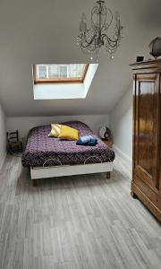 une chambre avec un lit et un lustre dans l'établissement Duplex de 120 m2 7 Pers-Centre-Parking Privé, à Gérardmer