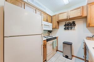 a kitchen with a white refrigerator and wooden cabinets at NE16-2 Sleepy Bear Camp condo in Branson West