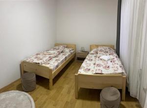 2 Einzelbetten in einem Zimmer mit 2 Stühlen in der Unterkunft Neno Apartmani in Novi Pazar + 2 Fotos