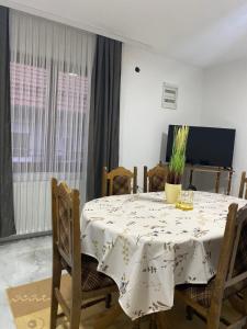 einen Esstisch mit einem weißen Tischtuch drauf in der Unterkunft Neno Apartmani in Novi Pazar