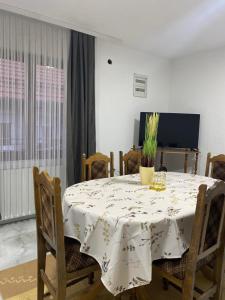 einen Esstisch mit einem weißen Tischtuch drauf in der Unterkunft Neno Apartmani in Novi Pazar