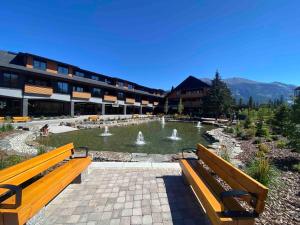 a building with a fountain in the middle of a park at Le Bucheron Stunning Spring Creek Luxury condo in Canmore