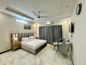 a hotel room with a bed and a chair at Dream Inn Guest House Islamabad in Islamabad