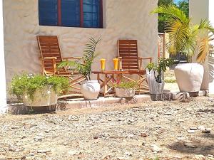 un patio con sillas, una mesa y macetas en Tajari Diani Beach Condo, en Galu