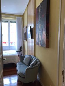 a living room with a chair and a painting on the wall at La casa de la escritora in Madrid +3 photos