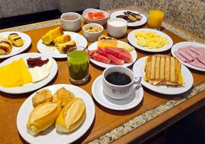 a table topped with plates of breakfast foods and drinks at Riale Imperial Flamengo in Rio de Janeiro