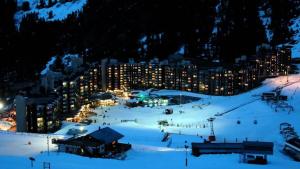 une station de ski éclairée la nuit dans la neige dans l'établissement Résidence Les Glaciers 1 Et 2 - Studio fonctionnel · Accès direct aux pistes · Vue sur la vallée MAE-3778, à Mâcot La Plagne 5 autres photos