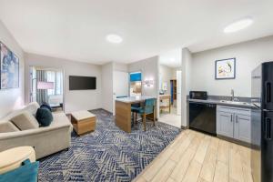 a living room with a couch and a kitchen at Executive Residency by Best Western Victorville in Victorville