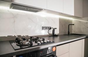a kitchen with a stove and a counter top at Tulip Residence & Rent Burebista Lux Apartament in Chişinău