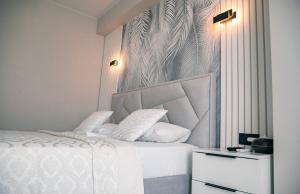 a bedroom with a white bed with white pillows at Tulip Residence & Rent Burebista Lux Apartament in Chişinău +10 photos