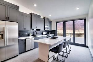 a kitchen with a large island with bar stools at Vizcaya #5 - Moab's Newest Luxury Rental with Private Hot Tub in Moab