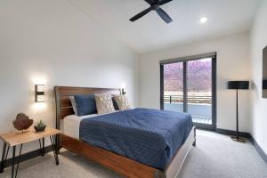 a bedroom with a bed and a large window at Vizcaya #5 - Moab's Newest Luxury Rental with Private Hot Tub in Moab