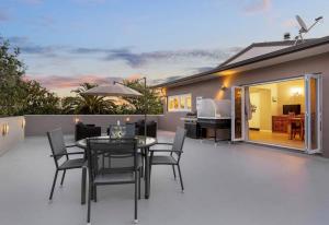 Un patio con una mesa y sillas en una terraza. en Lifestyle Living, en Huapai