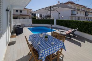 a patio with a table and an umbrella and a pool at Villa Penedo in São Domingos de Rana