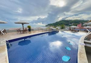 a large swimming pool with a view of the ocean at PIPAs BAY APARTHOTEL in Pipa