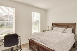a bedroom with a bed and a chair and windows at Family-Friendly Townhome in Murfreesboro! in Murfreesboro