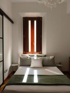 un letto grande in una stanza con una finestra di Fluère - Via Riva Reno a Bologna